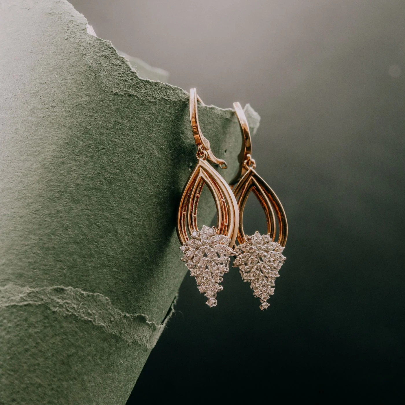 Gold and diamond earrings on a dark ground