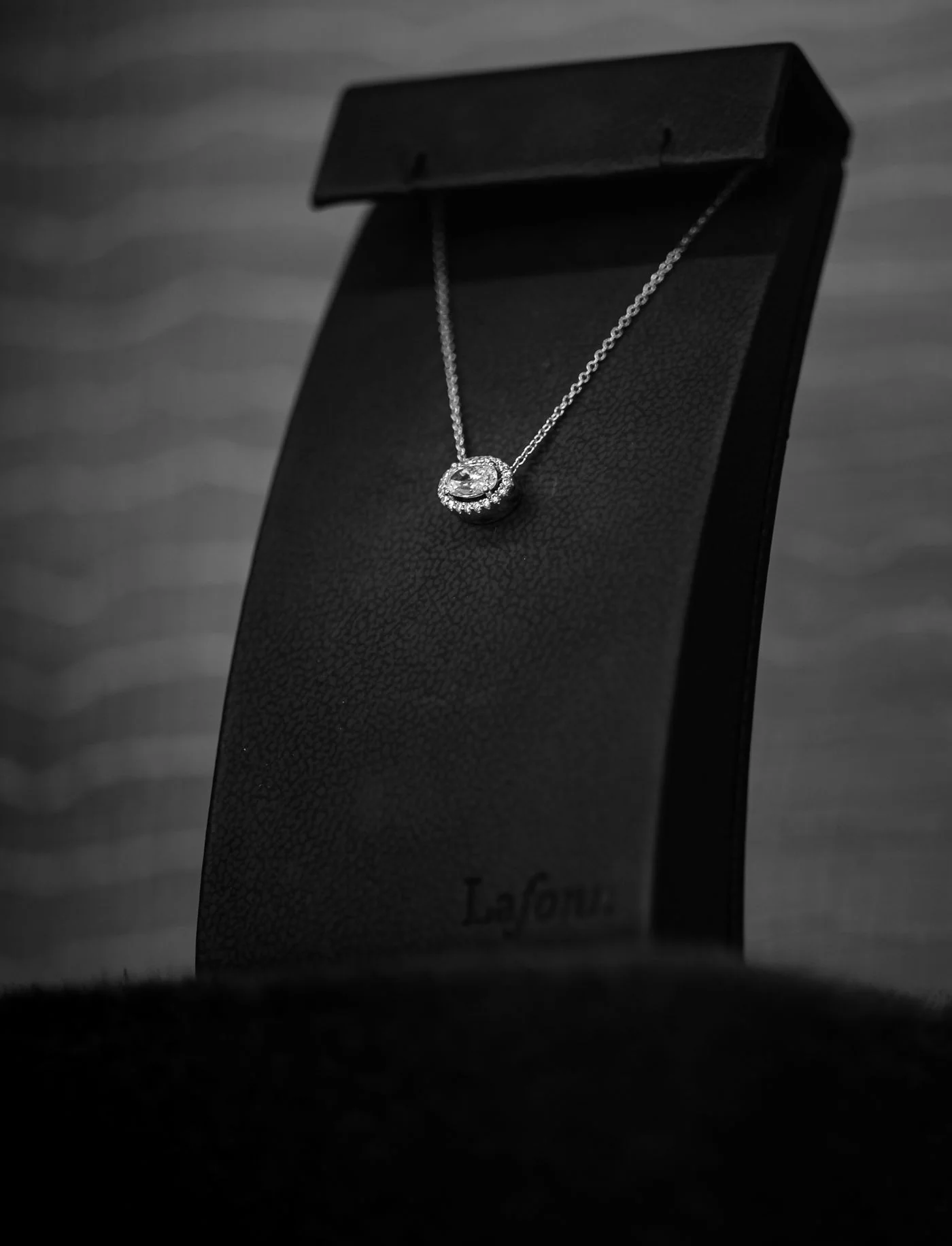 Diamond pendant necklace on a dark display
