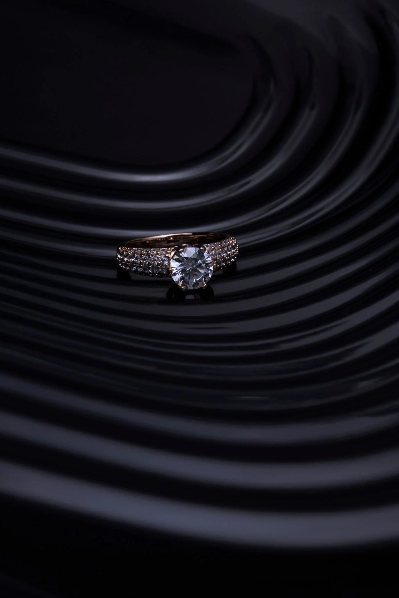 Diamond ring photographed close on dark stone